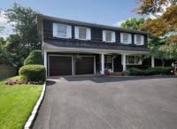 Two story cedar boarded home with driveway and garage